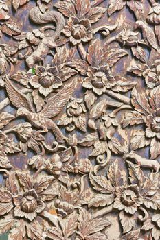 Carved animals and flowers on the wood background, vertical photo.