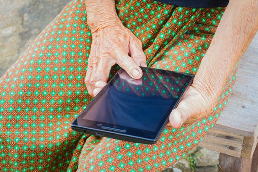 horizontal photo of closeup asian elder woman using tablet, technology concept.