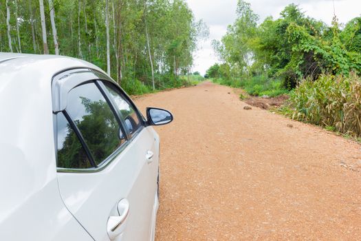 white car stop on the road on the dirt and gravel road.