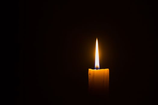 horizontal photo of candle on black background with copyspace