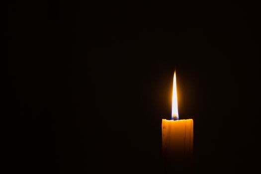 horizontal photo of candle on black background with copyspace