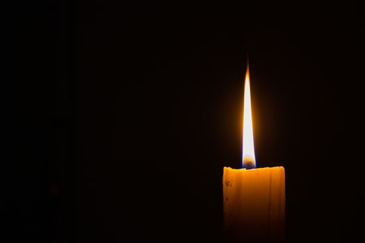 horizontal photo of candle on black background with copyspace