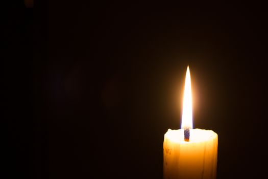 horizontal photo of candle on black background with copyspace