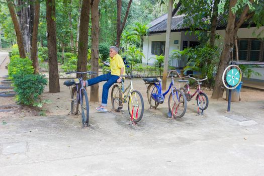 LAMPANG, THAILAND - NOVEMBER 5 : unidentified thai old man sitting on the poor fitness bike on November  5, 2016 in Lampang, Thailand.