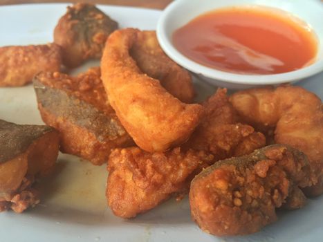 Horizontal photo of closeup fried fish with chili sauce. Shallow depth of field.