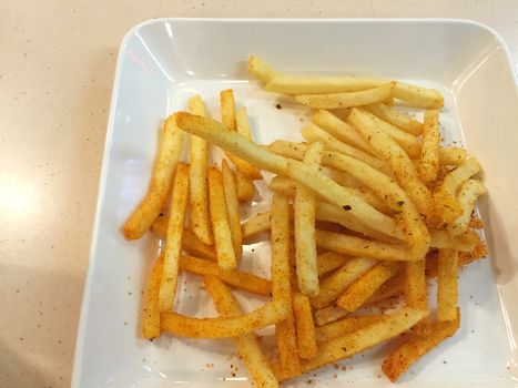 spicy french fries on white dish in restaurant, Thailand