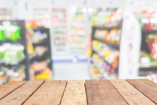 Wooden board empty table in front of blurred product shelf convenience store background with bokeh