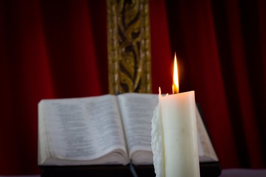 Bible with candles in the background. Low light scene.