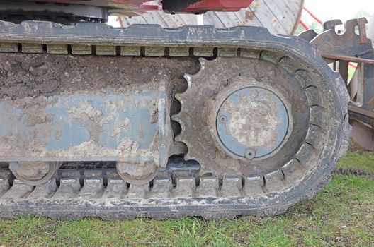 Rubber caterpillar bulldozer close-up, used and dirty