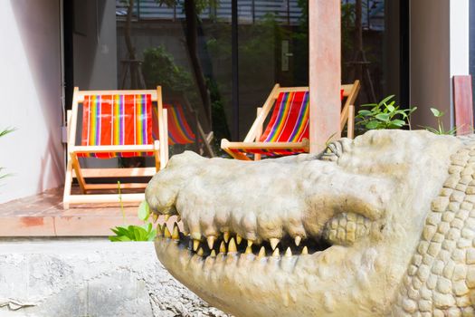 close-up crocodile on the blur background of beach chair in hotel