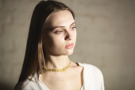 Portrait of beautiful fair young woman with fashion jewelry, one light source