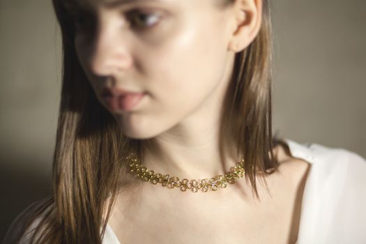 Portrait of beautiful fair young woman with fashion jewelry, one light source