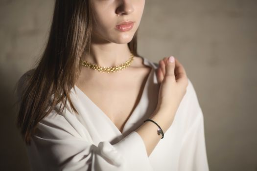 Portrait of beautiful fair young woman with fashion jewelry, one light source