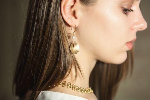 Portrait of beautiful fair young woman with fashion jewelry, one light source