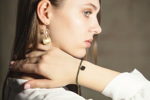 Portrait of beautiful fair young woman with fashion jewelry, one light source