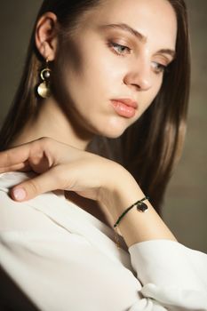 Portrait of beautiful fair young woman with fashion jewelry, one light source