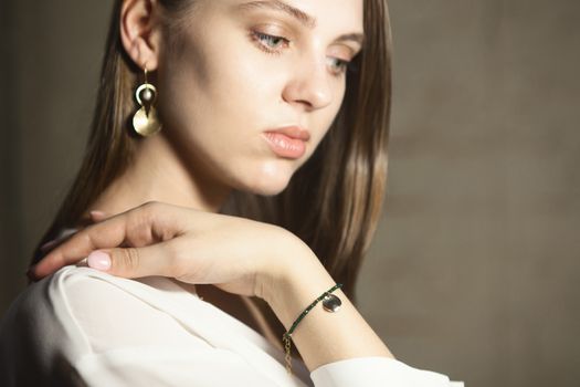 Portrait of beautiful fair young woman with fashion jewelry, one light source