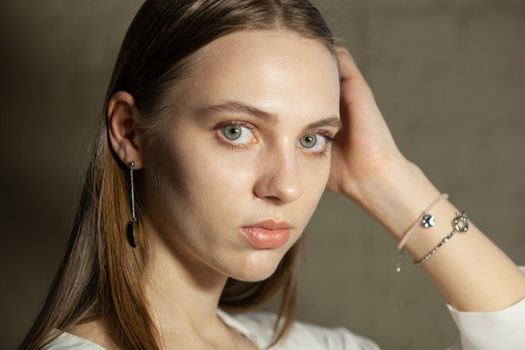 Portrait of beautiful fair young woman with fashion jewelry, one light source