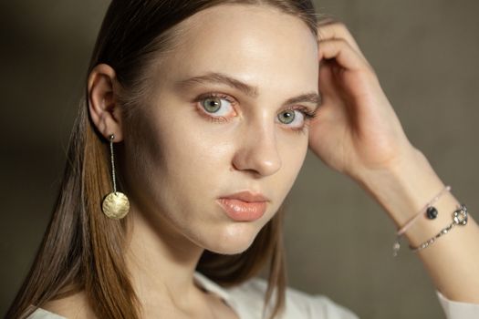 Portrait of beautiful fair young woman with fashion jewelry, one light source