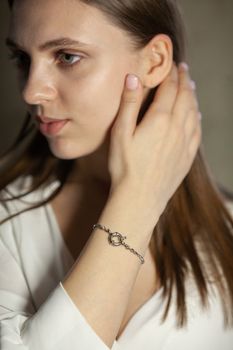 Portrait of beautiful fair young woman with fashion jewelry, one light source