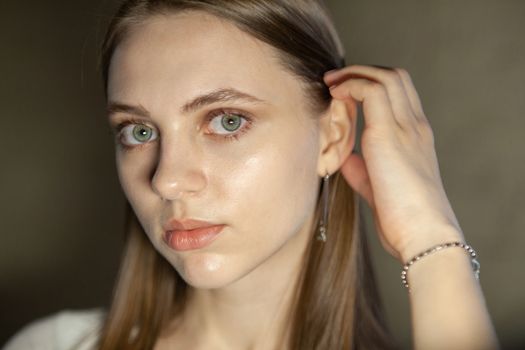 Portrait of beautiful fair young woman with fashion jewelry, one light source