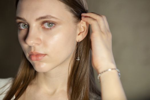Portrait of beautiful fair young woman with fashion jewelry, one light source