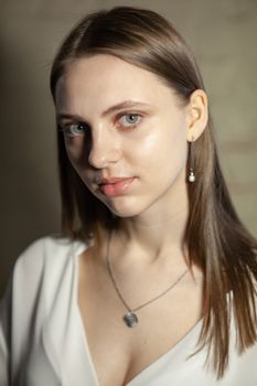 Portrait of beautiful fair young woman with fashion jewelry, one light source