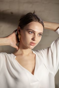 Portrait of beautiful fair young woman with fashion jewelry, one light source