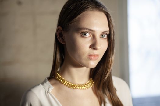 Portrait of beautiful fair young woman with fashion jewelry, one light source