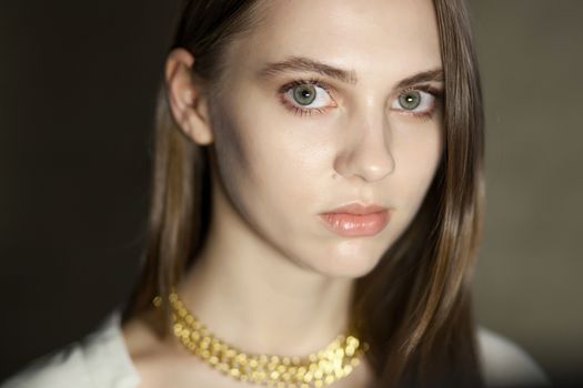 Portrait of beautiful fair young woman with fashion jewelry, one light source