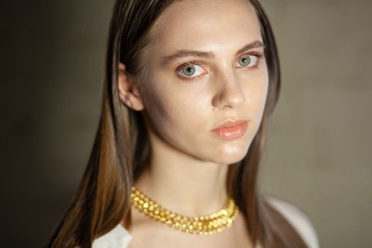 Portrait of beautiful fair young woman with fashion jewelry, one light source