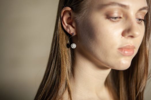 Portrait of beautiful fair young woman with fashion jewelry, one light source