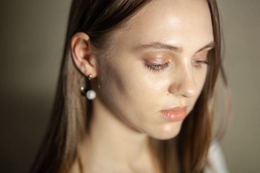 Portrait of beautiful fair young woman with fashion jewelry, one light source