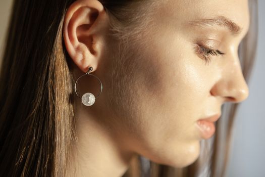 Portrait of beautiful fair young woman with fashion jewelry, one light source