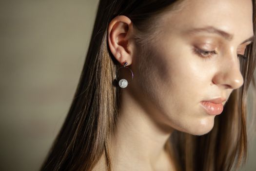 Portrait of beautiful fair young woman with fashion jewelry, one light source