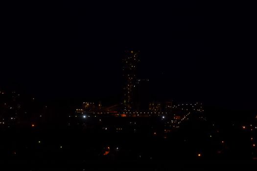 The building of a cement plant at night, the lights of a lamp lighting a factory. Industrial facility.