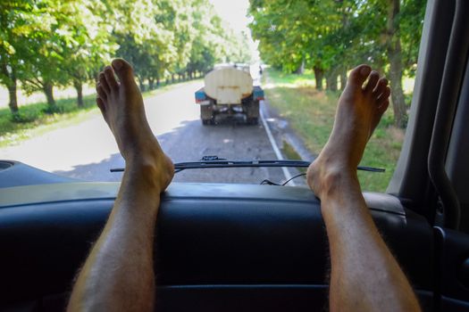 The passenger put his feet on the panel in the car. rest in the car.