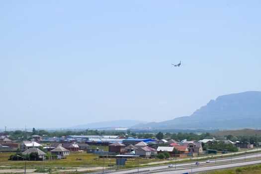 The plane lands over the settlement and the track.
