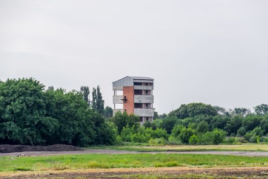 Unfinished multi-storey house in the park. A house in the woods.