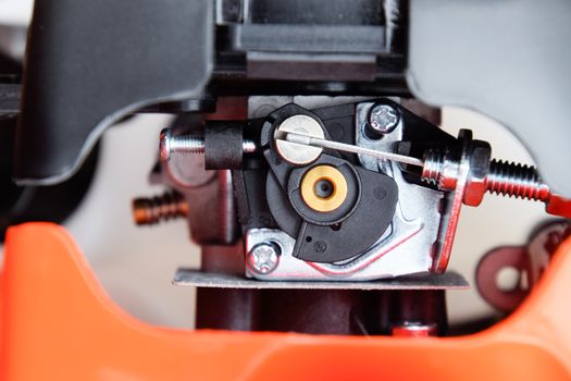 Elements of the fuel system of a gasoline trimmer. Fuel tank and carburetor trimmer engine. Fuel system of a carburetor two-stroke engine. Trimer gascosis with a leaf for mowing grass and shrubs.