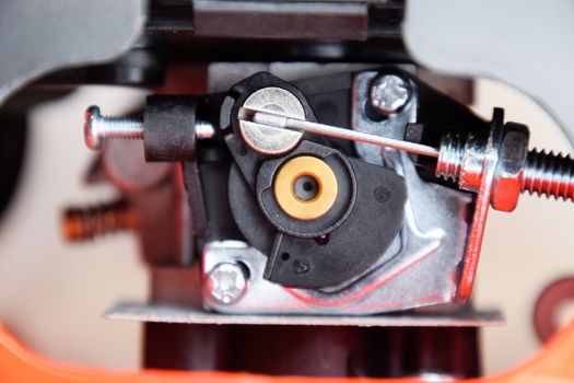 Elements of the fuel system of a gasoline trimmer. Fuel tank and carburetor trimmer engine. Fuel system of a carburetor two-stroke engine. Trimer gascosis with a leaf for mowing grass and shrubs.