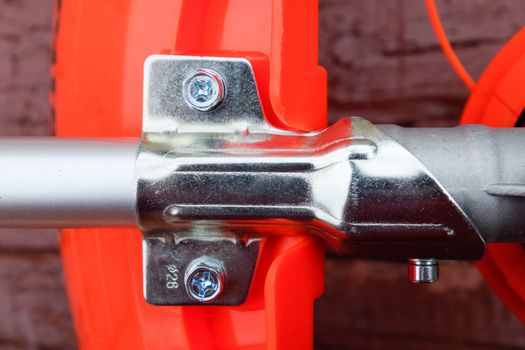 Fasteners for gas trimmer construction. Bolts and screws on the trimer body. Trimer gascosis with a leaf for mowing grass and shrubs.
