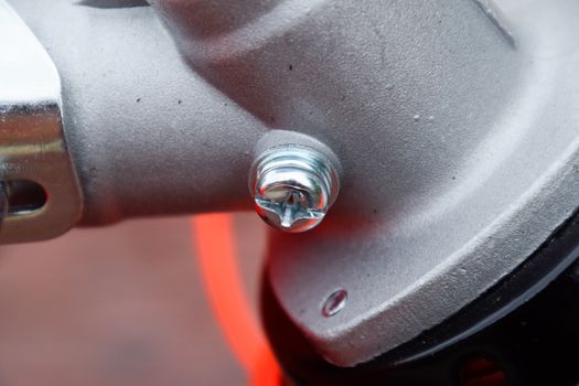 Fasteners for gas trimmer construction. Bolts and screws on the trimer body. Trimer gascosis with a leaf for mowing grass and shrubs.