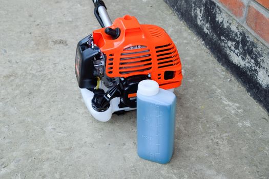 Prepared fuel mixture for a two stroke gasoline trimmer engine. Gasoline trimmer. Trimer gascosis with a leaf for mowing grass and shrubs.