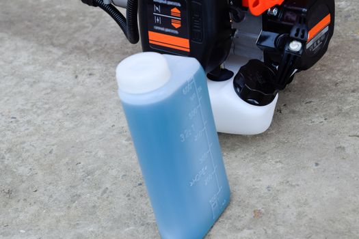 Prepared fuel mixture for a two stroke gasoline trimmer engine. Gasoline trimmer. Trimer gascosis with a leaf for mowing grass and shrubs.