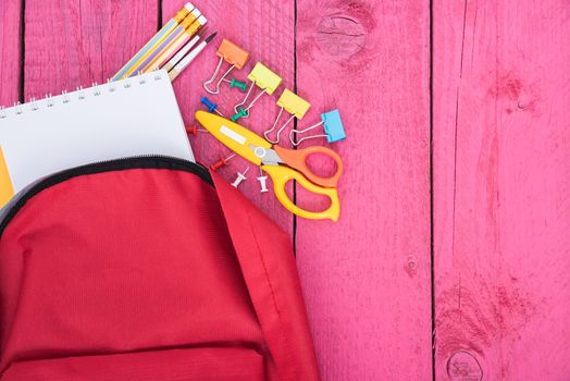 Top view Red bag backpack for education children on pink wooden  background back to school concept