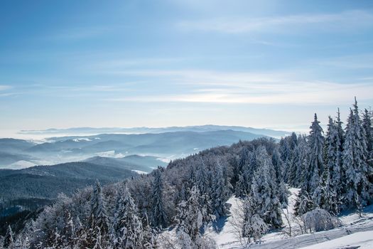 Picturesque and scenic panorama of winter mountains on a sunny day on the blue sky background with copy space.