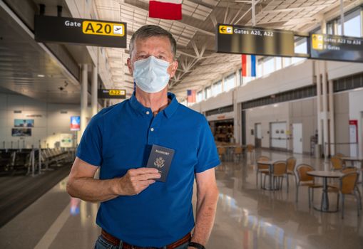 Mockup of airport terminal with casual senior adult holding passport and wearing mask against coronavirus