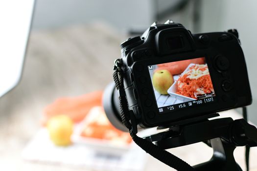 Concept image  -  rear view of DSLR camera making a food photography in the photo studio