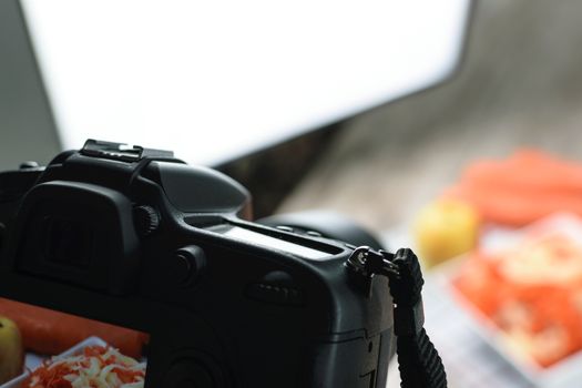 Concept image  -  rear view of DSLR camera making a food photography in the photo studio